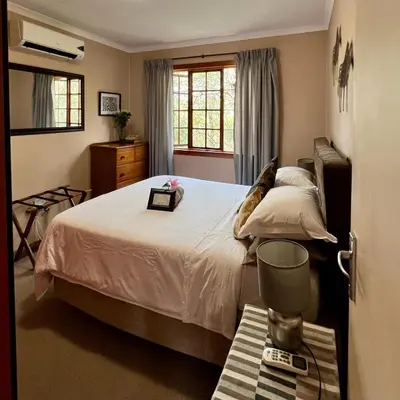 a bedroom with a large bed and a window at Luxury Treetop Lodge in Marloth Park