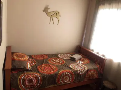 a bedroom with a bed with a deer on the wall at Luxury Treetop Lodge in Marloth Park
