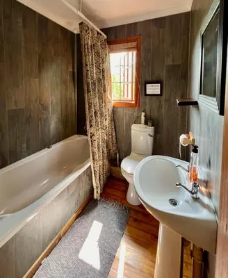 a bathroom with a tub and a toilet and a sink at Luxury Treetop Lodge in Marloth Park