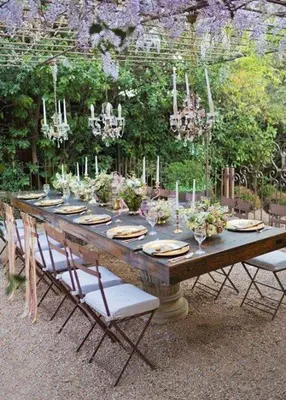 a long wooden table with chairs and flowers on it at Midrand Wild Goose Guest House B&B in Midrand