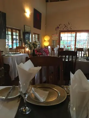 a table in a restaurant with a plate of food at Midrand Wild Goose Guest House B&B in Midrand