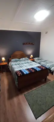 a bedroom with two beds and two lamps on tables at Guesthouse 914 in Sabie
