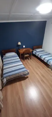 a room with two beds and a table in it at Guesthouse 914 in Sabie