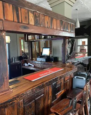 a wooden bar with a desk in a room at SIMA SILVER LODGE in Tzaneen