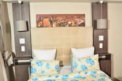 a bedroom with a bed and a painting on the wall at RAMATA GUEST HOUSE in Pretoria
