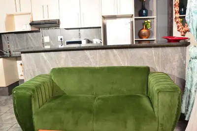 a green couch sitting in the middle of a kitchen at RAMATA GUEST HOUSE in Pretoria