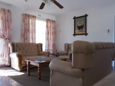 a living room with a couch and chairs and a table at El Rancho Grande in Warmbaths