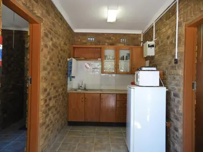 a kitchen with a refrigerator and a brick wall at El Rancho Grande in Warmbaths