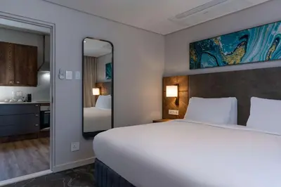 a bedroom with a large white bed and a mirror at Radisson Hotel and Convention Centre OR Tambo Airport in Johannesburg