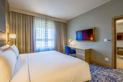 a hotel room with a large bed and a desk at Radisson Hotel and Convention Centre OR Tambo Airport in Johannesburg