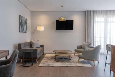a living room with chairs and a couch and a table at Radisson Hotel and Convention Centre OR Tambo Airport in Johannesburg
