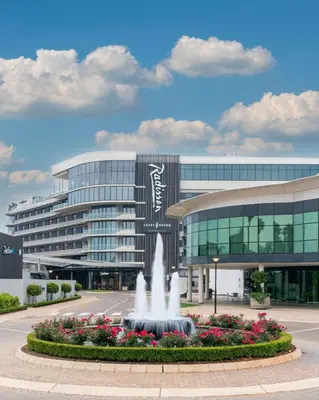 a large building with a fountain in front of it at Radisson Hotel and Convention Centre OR Tambo Airport in Johannesburg