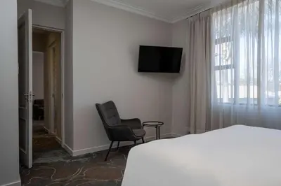 a bedroom with a bed and a chair and a television at Radisson Hotel and Convention Centre OR Tambo Airport in Johannesburg