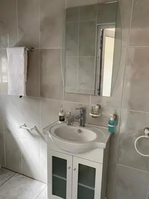a bathroom with a sink and a mirror at Hush Guest House in Northam