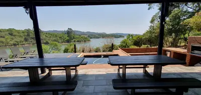 two benches on a patio with a view of a lake at DaGama Dam - White River - Kestrel - House 21 in White River