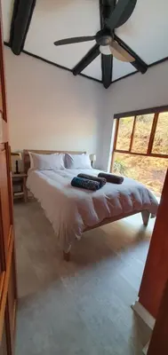 a bedroom with a bed with a ceiling fan at DaGama Dam - White River - Kestrel - House 21 in White River