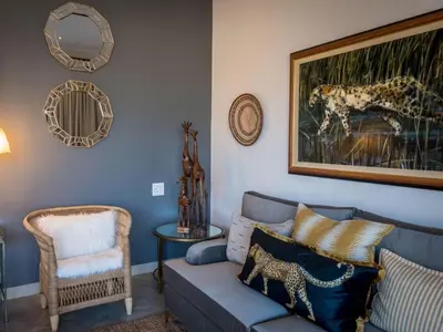 a living room with a couch and a picture of a leopard at Safari Moon Luxury Bush Lodge in Hoedspruit