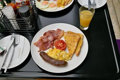 a black table with a plate of breakfast food at SleepOver Matoks in Matoks