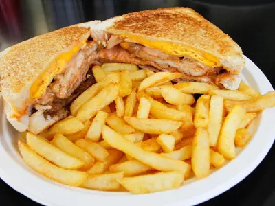 a sandwich and french fries on a white plate at SleepOver Matoks in Matoks