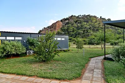 a black house with a hill in the background at SleepOver Matoks in Matoks