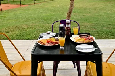 a black table with two plates of food and drinks at SleepOver Matoks in Matoks