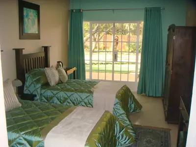 a bedroom with two beds and a window at Heatherdale Guesthouse & Shuttle Services in Pretoria