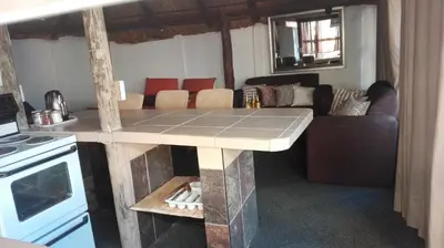 a kitchen with a table and a living room at Heatherdale Guesthouse & Shuttle Services in Pretoria
