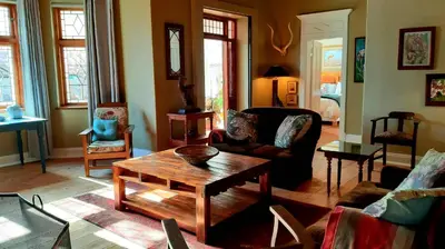 a living room with a table and a couch at Bluebell Country House in Dullstroom