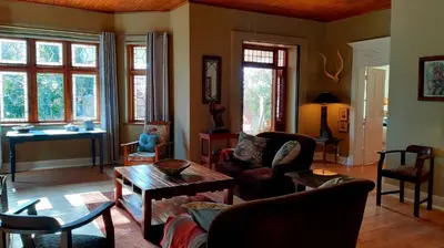 a living room filled with furniture and a table at Bluebell Country House in Dullstroom