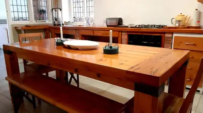 a wooden table with two candles on it in a kitchen at Bluebell Country House in Dullstroom
