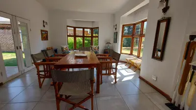 a dining room with a wooden table and chairs at Bluebell Country House in Dullstroom