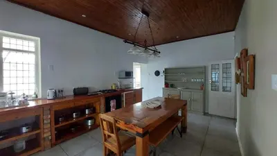 a large kitchen with a wooden table in a room at Bluebell Country House in Dullstroom