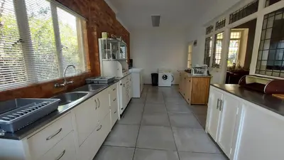 a large kitchen with a sink and a refrigerator at Bluebell Country House in Dullstroom
