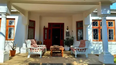 a porch with two chairs and a coffee table at Bluebell Country House in Dullstroom