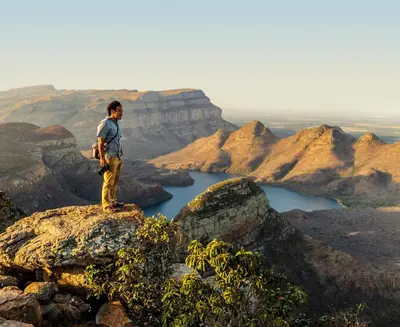 a man standing on top of a mountain overlooking a river at Bush Villas on Kruger in Phalaborwa