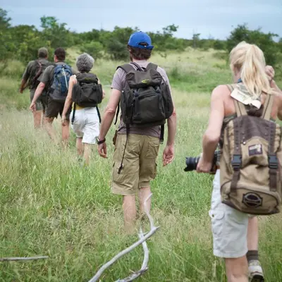a group of people walking through a field at Bush Villas on Kruger in Phalaborwa