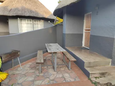 a patio with a bench and a house at Graskop family retreat and backpackers in Graskop