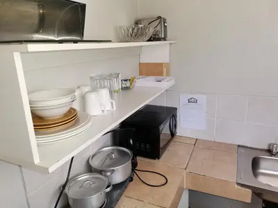 a kitchen with a counter with bowls and a sink at Graskop family retreat and backpackers in Graskop