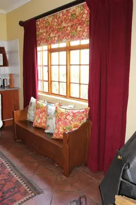 a living room with a couch and a window at Jocks Cottages in Dullstroom