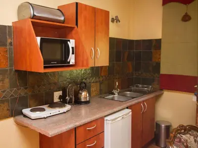 a kitchen with a sink and a microwave at Jocks Cottages in Dullstroom