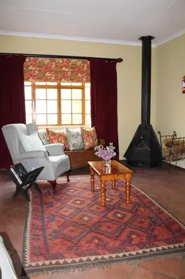 a living room with a couch and a fireplace at Jocks Cottages in Dullstroom