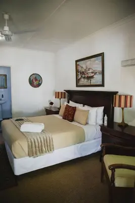 a bedroom with a large bed in a room at Lydenburg Manor Guest House in Lydenburg