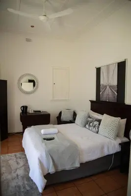 a bedroom with a large bed in a room at Lydenburg Manor Guest House in Lydenburg