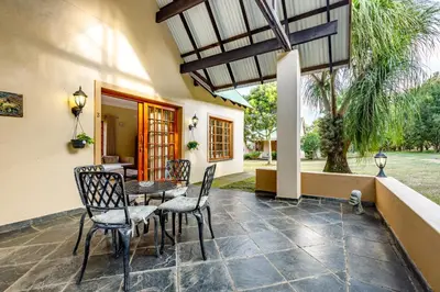 a patio with a table and chairs and a building at Country Lane Lodge in White River