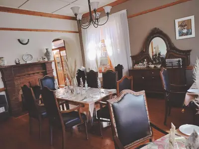 a dining room with a table and chairs and a mirror at Oregon Place Guest House in Middelburg