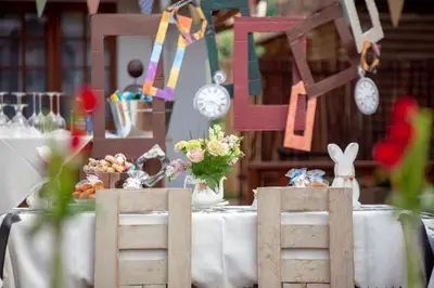 a table with two wooden chairs and flowers and clocks at Oregon Place Guest House in Middelburg