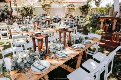 a long wooden table with white chairs and flowers at Oregon Place Guest House in Middelburg
