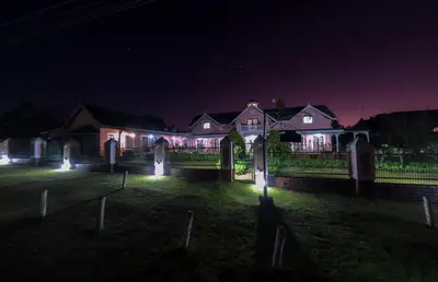 a house with lights in a yard at night at Westlodge at Graskop B&B in Graskop
