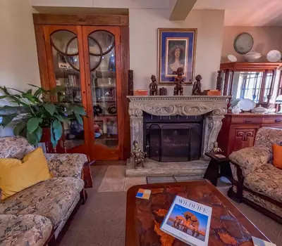 a living room with a fireplace and a table at Westlodge at Graskop B&B in Graskop