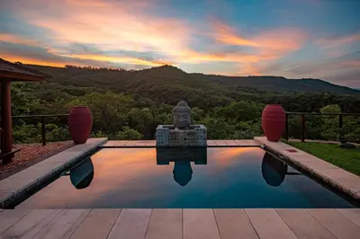 a swimming pool with a statue in the middle at The Zarafa in Hazyview